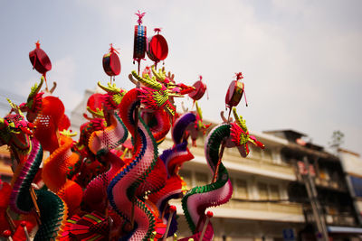 Low angle view of multi colored umbrellas on street against sky