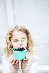 Girl holding seedling in pot