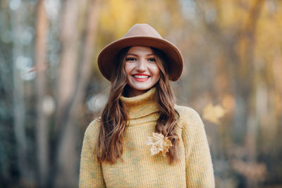 Young woman wearing hat standing outdoors