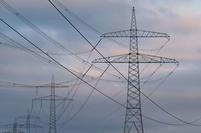 Low angle view of electricity pylon against sky