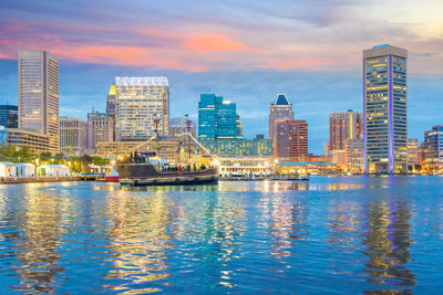 Modern buildings by sea against sky in city