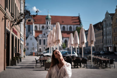 Woman on street amidst buildings in city