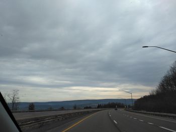 Vehicles on highway against sky