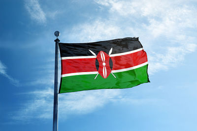 Low angle view of flag against blue sky