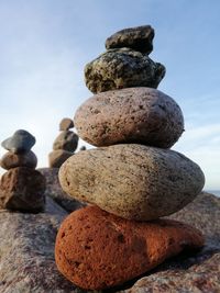 Stack of stones on beach against sky