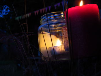 Close-up of lit candle in the dark