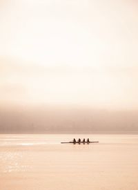 People on boat in sea against sky