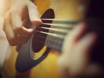 Cropped image of person playing guitar