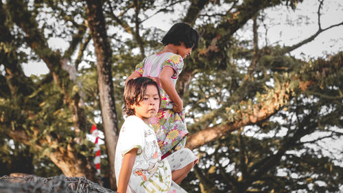 Full length of mother and daughter against trees