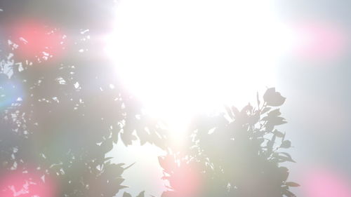 Low angle view of illuminated sun against clear sky