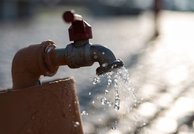 Close-up of water drop from faucet 