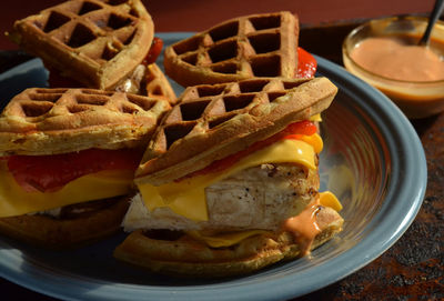 Chicken and savory waffle sandwiches with cheddar cheese, roasted red peppers, aioli sauce