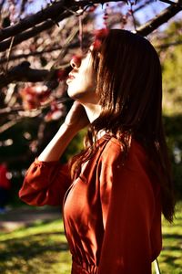 Side view of young woman standing in park