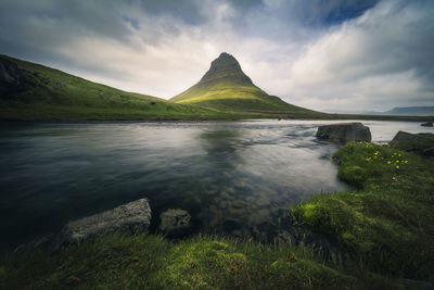 Low-angle view of kirkjufell mountain against dramatic cloudy sky, iceland, snæfellsnes peninsula