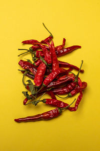 High angle view of red chili pepper against yellow background