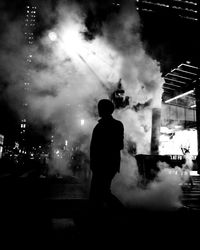 Rear view of silhouette man standing at night