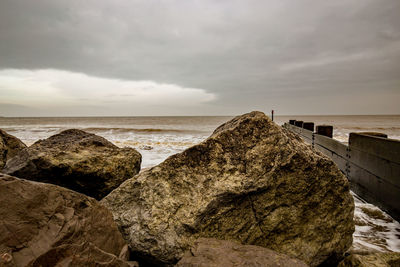Rocks on beach against sky