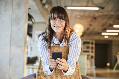 Portrait of smiling woman using mobile phone