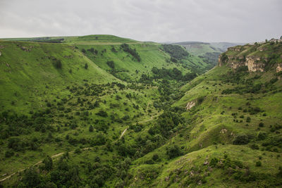 Scenic view of green mountains against sky