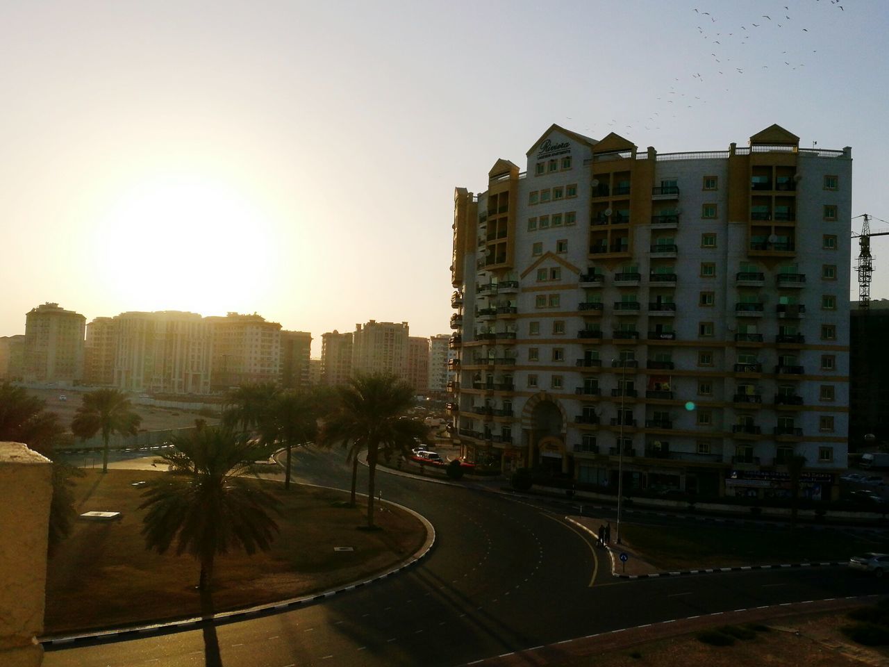 building exterior, architecture, city, built structure, sunlight, outdoors, clear sky, travel destinations, apartment, city life, sky, residential building, cityscape, skyscraper, no people, urban skyline, day