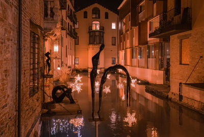 People in illuminated building at night