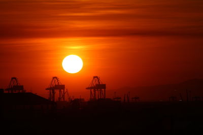 Scenic view of sunset over silhouette industry