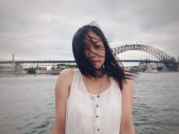Woman standing by sea against sky
