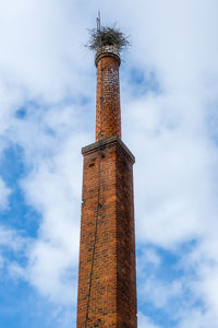 Brick chimney from an old abandoned factory with stork nest