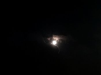 Low angle view of illuminated moon in sky at night