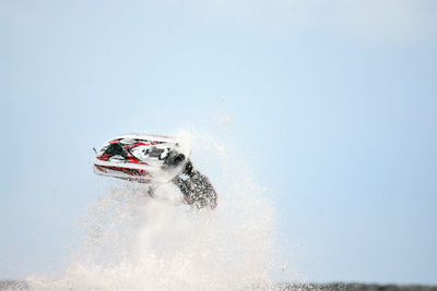 Man performing stunt with jet boat against sky