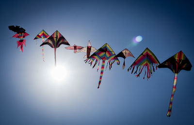 Low angle view of kites flying against clear sky