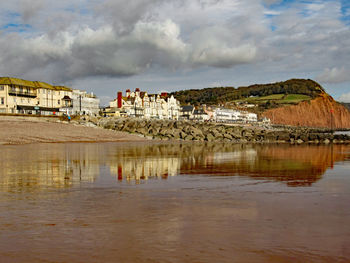 Scenic view of lake by buildings against sky