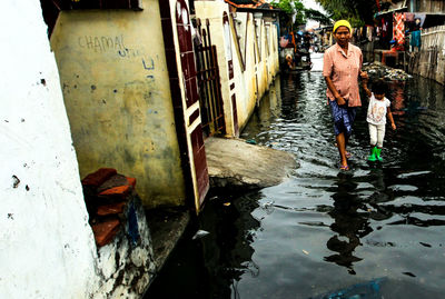 Rear view of people walking on canal