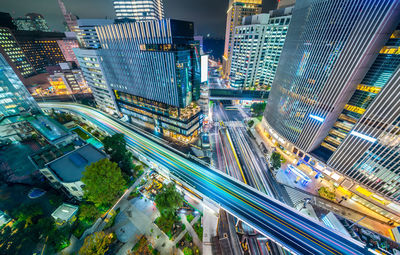 High angle view of illuminated street amidst buildings in city at night