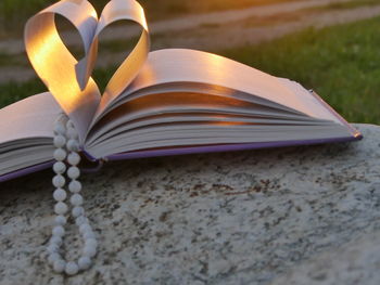 Necklace with heart shape pages of book during sunset