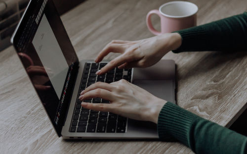 The hands of girl are typing in laptop. workspace work at home. online business. distance learning. 