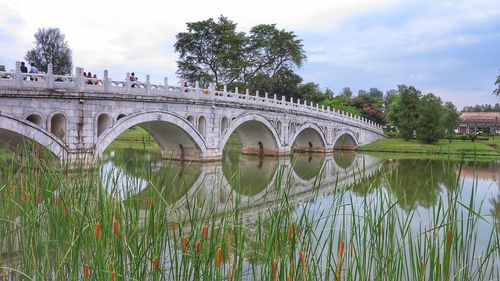 Arch bridge over river against sky