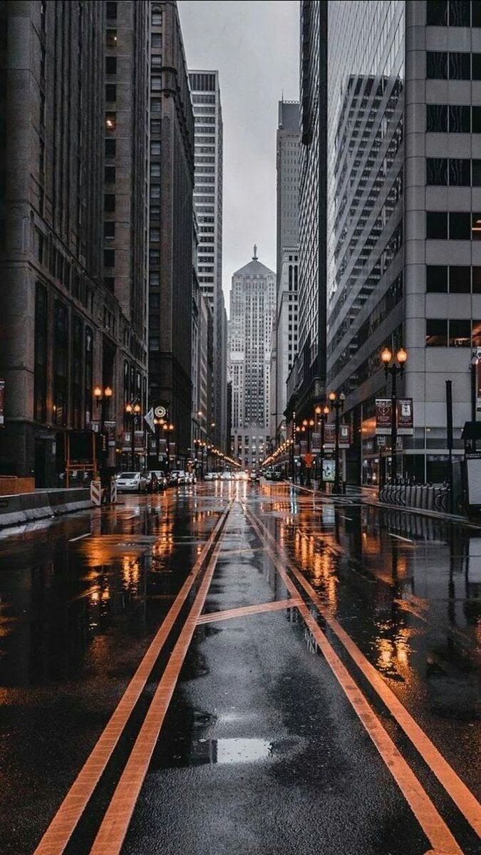 ILLUMINATED ROAD AMIDST BUILDINGS IN CITY