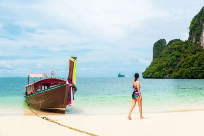 Rear view of man on beach against sky