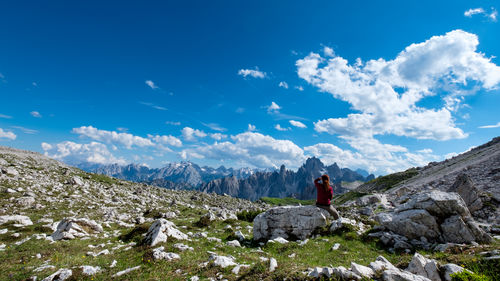 Man standing on rock against sky