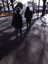 Rear view of people walking on road in winter