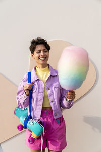 Happy woman with roller skates holding cotton candy