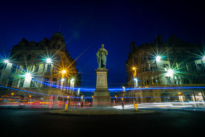 Illuminated statue of city against sky at night