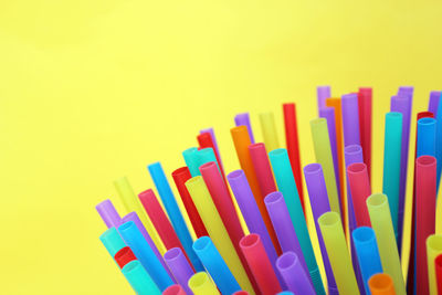 Close-up of multi colored pencils against yellow background