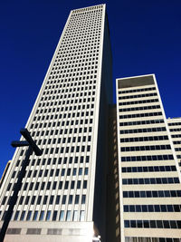 Low angle view of modern building against clear blue sky