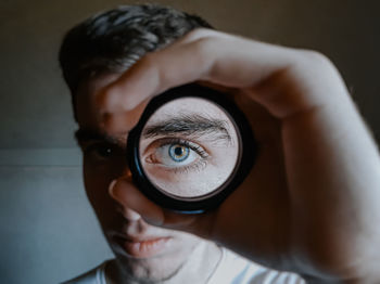 Close-up portrait of young man holding camera