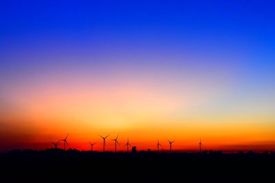 Silhouette of wind turbines at sunset