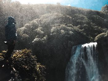 High angle view of woman standing by waterfall