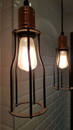 Close-up of illuminated light bulb against wall at home
