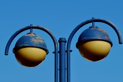 Low angle view of street light against blue sky